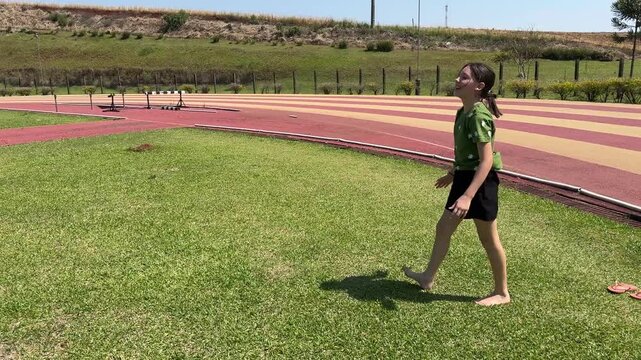 garota faz exerc&iacute;cios de ginasta ao ar livre 