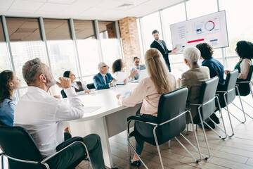 Professional team engaged in a corporate presentation and brainstorming session in a modern office environment