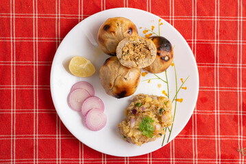 Litti Chokha, the iconic dish of Bihar, is made of wheat balls stuffed with spiced sattu, roasted over fire, and served with mashed potato, brinjal, and tomato. It’s a rustic, flavorful, and cultural 