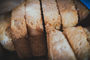 Close-up of freshly baked, golden brown sliced bread or rusk, beautifully arranged in a rustic setting in India. The warm tones and visible texture highlight its artisanal quality.