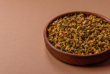 Dried chamomile flowers, herbal tea in a bowl for a hot morning drink. Dried chamomile