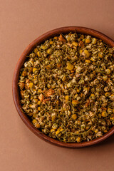 Dried chamomile flowers, herbal tea in a bowl for a hot morning drink. Dried chamomile