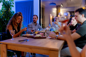 Group of Friends Enjoying Dinner Together in Candlelit Setting