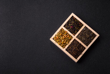 A wooden box with several types of dried tea, green, black, fruit, and chamomile. Dry tea in the box
