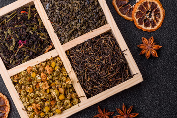 A wooden box with several types of dried tea, green, black, fruit, and chamomile. Dry tea in the box
