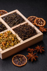 A wooden box with several types of dried tea, green, black, fruit, and chamomile. Dry tea in the box