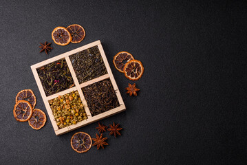 A wooden box with several types of dried tea, green, black, fruit, and chamomile. Dry tea in the box