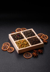 A wooden box with several types of dried tea, green, black, fruit, and chamomile. Dry tea in the box