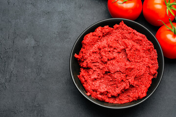 Fresh tomato paste or puree on black background	