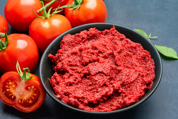 Fresh tomato paste or puree on black background	