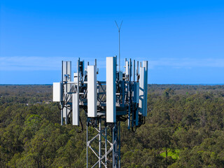 Drone aerial photograph of the top section of a large Telecommunications Tower located in a residential area amongst lush bushland in regional NSW, Australia.