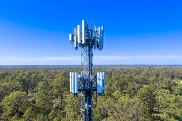 Drone aerial photograph of the top section of a large Telecommunications Tower located in a residential area amongst lush bushland in regional NSW, Australia.