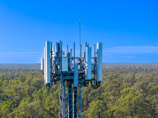 Drone aerial photograph of the top section of a large Telecommunications Tower located in a residential area amongst lush bushland in regional NSW, Australia.