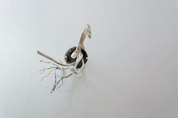 An intriguing display of disconnected wiring featuring colorful twisted cables against a minimalist wall, showcasing a blend of modern artistry with elements of creative electrical installation