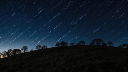 Night sky panorama with star trails over a dark landscape