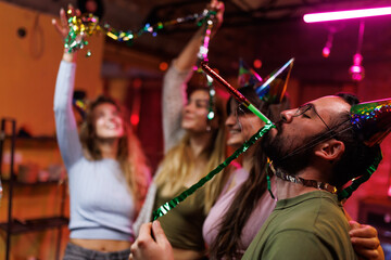 Group of friends celebrating a festive occasion with colorful decorations and party hats in a cheerful atmosphere
