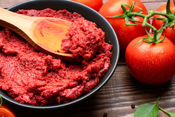 Fresh tomato paste or puree on wooden background	