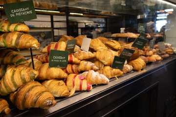 Croissants with various fillings on a counter, among them are signs saying what filling they have
