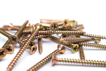 Close-up of golden self-tapping screws with Phillips heads on white background, construction fasteners used in woodworking, metalwork and DIY projects, concept of industrial hardware and precision too
