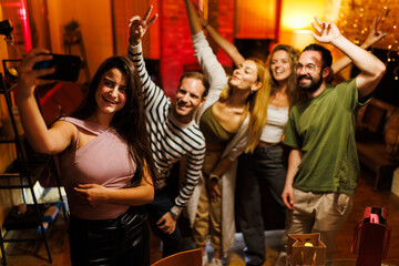 Group of friends enjoying a lively gathering captured in a cheerful selfie together