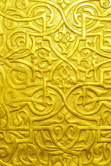 Golden ornamental texture with intricate arabesque patterns and embossed details, radiating elegance and luxury, perfect for backgrounds, design elements, or cultural art concepts.