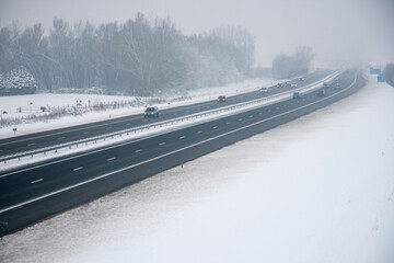 Traffic on the highway during snowfall and fog.