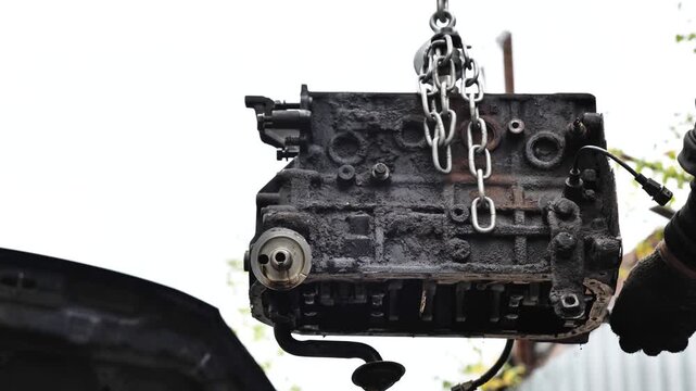 Mechanic repairing car engine block in service station