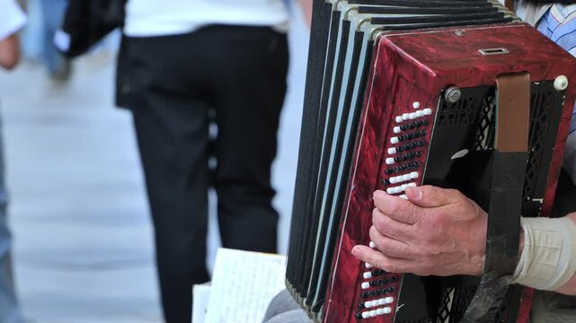 Street musician playing red accordion in Moscow