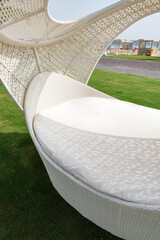 White beach chair and sun loungers on the hotel ground in a green grass. Beach furniture. Garden furniture
