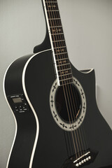 Elegant black guitar rests against a soft backdrop, showcasing its unique design