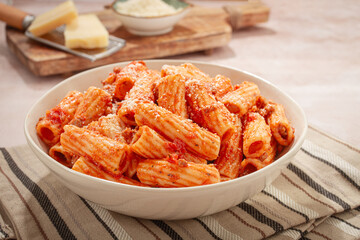 Rigatoni pasta with meat sauce and parmesan cheese on a light table, top view, homemade, no people,