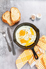 Freshly cooked eggs in a pan, served with bread, on the kitchen counter,breakfast, natural light, no people,