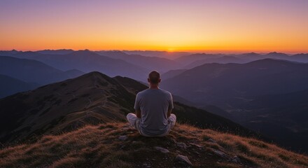 Person contemplating sunrise over misty mountains