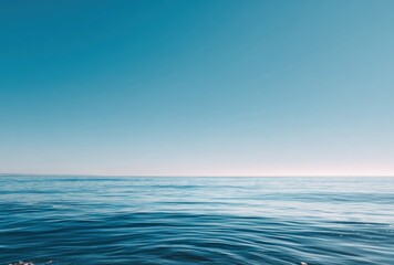 Obraz premium Calm ocean horizon under a clear, bright blue sky. Minimalist landscape with water and sky