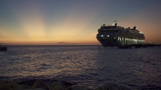 Willemstad, Curacao: Norwegian Jade cruise ship in moored in Cura&ccedil;ao with a stunning sunset. Norwegian Cruise Line (NCL). Mega Cruise Terminal near Renaissance Park.