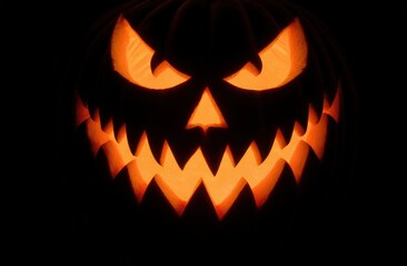 Glowing jack-o'-lantern with menacing expression in dark background