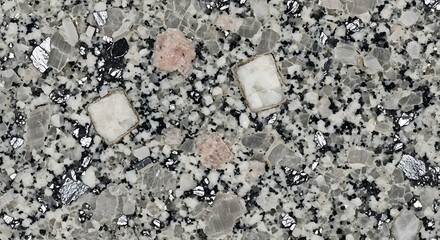 Close up of a speckled granite countertop with pink and white inclusions.