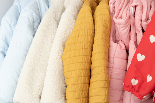 Close up view of warm childrens outerwear showing detail of colorful winter jackets and coats, seasonal clothing for kids