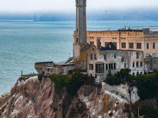 Alcatraz Island in San Francisco Bay features the historic prison, rugged cliffs, a guard tower,...