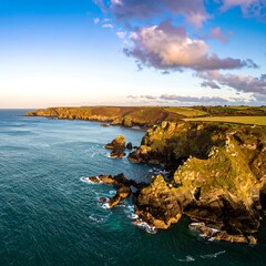 Coastal Scenery, Rocky Cliffs, Calm Ocean, Cloudy Sky at Sunset