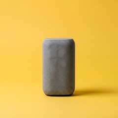Sleek, unbranded matte grey minimalist smart speaker standing upright on a seamless vibrant yellow studio background with soft, diffused lighting highlighting its modern design and subtle textures.