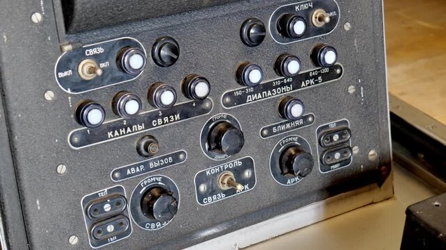 Old Russian military radar control panel closeup, indicator lights, markers, buttons, dials, switches, retro technology vintage analog metal console with cyrillic labels, industrial detail closeup