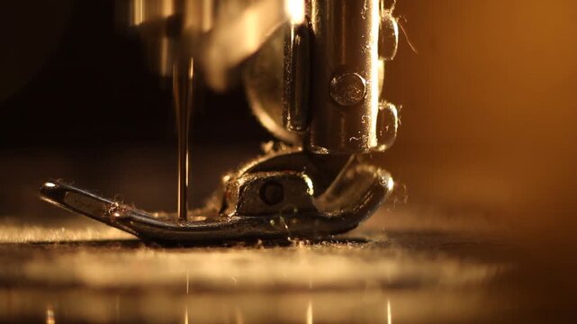 Intimate macro shot of an antique sewing machine's needle rapidly moving, illuminated by warm, ambient light on the metal presser foot and base.