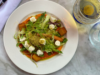 Mixed vegetable salad starter on Romesco sauce with cheese crispy panisse