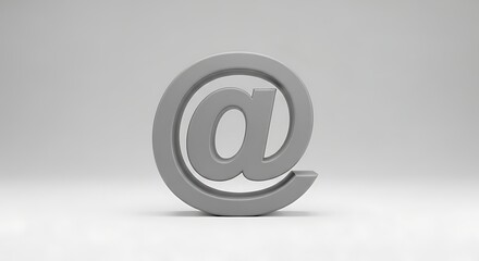 A gray at symbol standing upright on a white surface against a gradient gray background studio shot