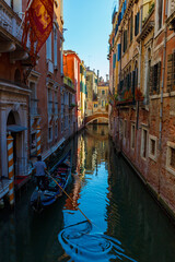 Colourful canal in Venice with a gondola going down the canal
