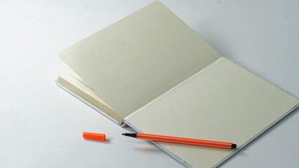 Blank notebook with orange pen inviting creative ideas or professional planning