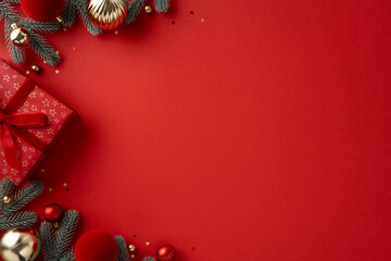 Vibrant red background with a wrapped gift, ornaments, and frosted pine branches captures a festive...