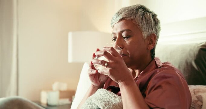Sick, mature woman and drinking water with pills for cold recovery, multivitamin or insomnia in bed. Healthcare, flu prescription and senior person in bedroom for sleep with illness, fever or rest
