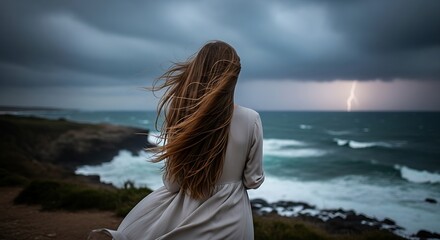 Fototapeta premium Woman watching stormy ocean waves and lightning.